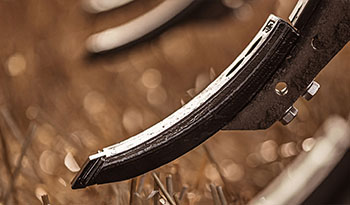 Close-up of Väderstad cultivator points with a field in the background.