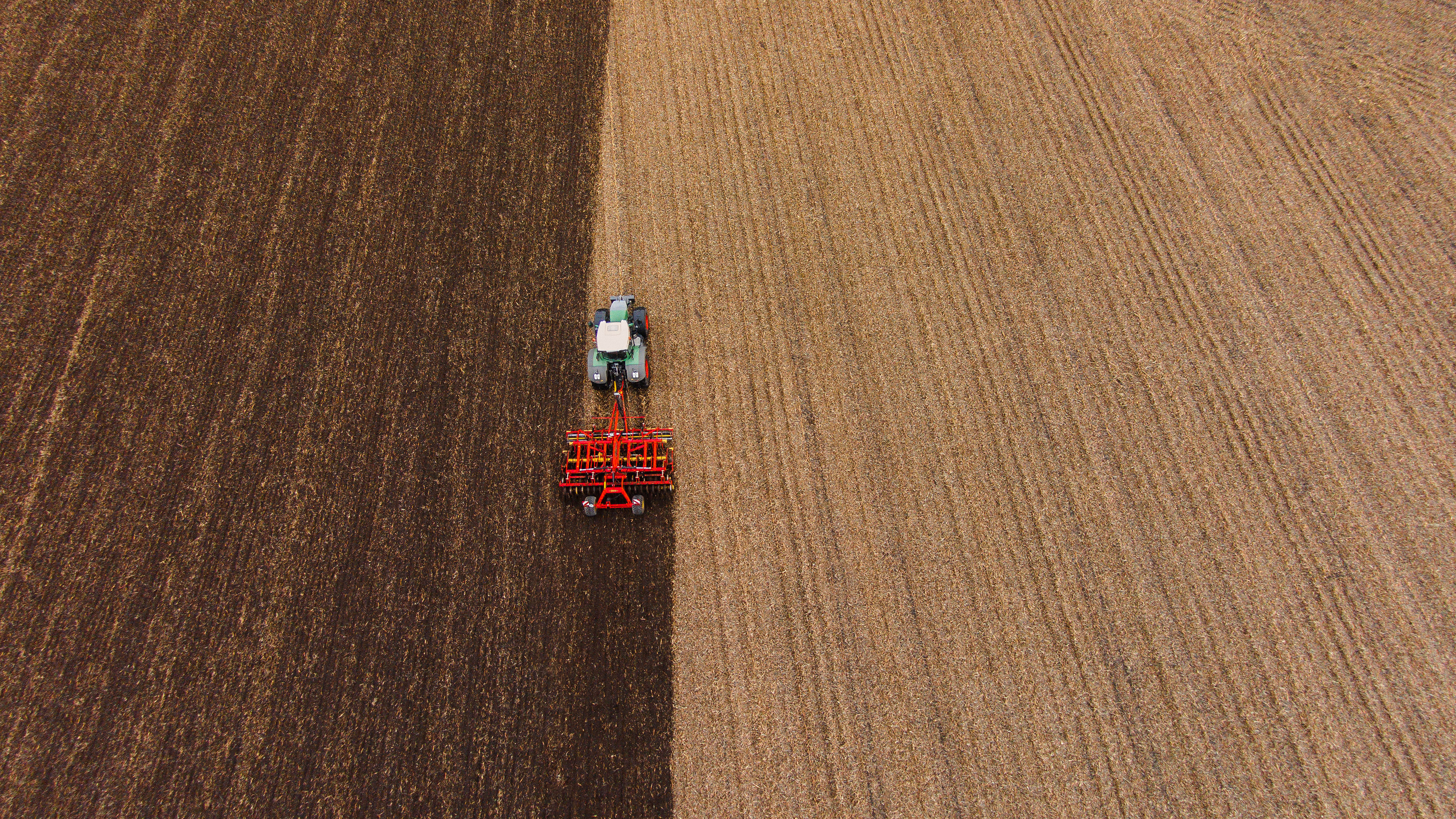 Field with a red  cultivator.